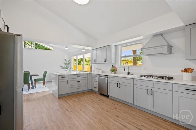 4750 Sylvan Dr, Savannah, GA 31405 - kitchen with appliances with stainless steel finishes, custom exhaust hood, gray cabinets, vaulted ceiling, and light countertops