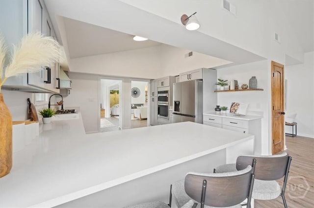4750 Sylvan Dr, Savannah, GA 31405 - kitchen featuring stainless steel appliances, light countertops, open shelves, a peninsula, and gray cabinets