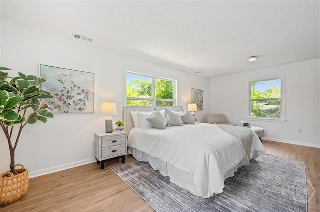 4750 Sylvan Dr, Savannah, GA 31405 - bedroom with light wood finished floors, a textured ceiling, and baseboards