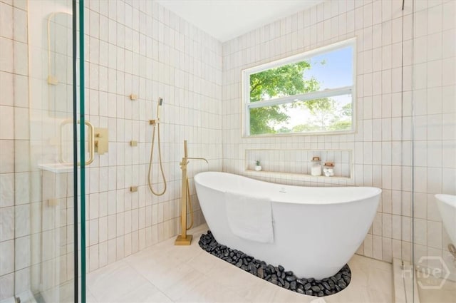 4750 Sylvan Dr, Savannah, GA 31405 - full bath featuring tile walls, a freestanding tub, a shower stall, and tile patterned floors