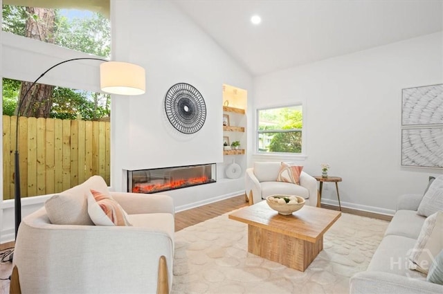 4750 Sylvan Dr, Savannah, GA 31405 - living area with high vaulted ceiling, a glass covered fireplace, wood finished floors, recessed lighting, and baseboards