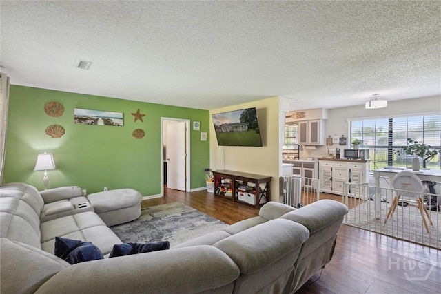 151 Ogeechee Ave, Bloomingdale, GA 31302 - living room featuring a textured ceiling, dark wood finished floors, and baseboards