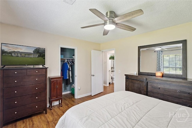 151 Ogeechee Ave, Bloomingdale, GA 31302 - bedroom with wood finished floors, a spacious closet, baseboards, a textured ceiling, and ceiling fan