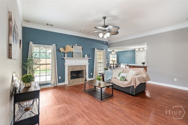 210 Pebblestone Dr, Bloomingdale, GA 31302 - living room featuring a ceiling fan, wood finished floors, a tiled fireplace, crown molding, and baseboards