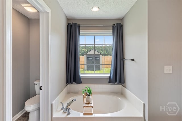 210 Pebblestone Dr, Bloomingdale, GA 31302 - bathroom with toilet, a garden tub, and a textured ceiling