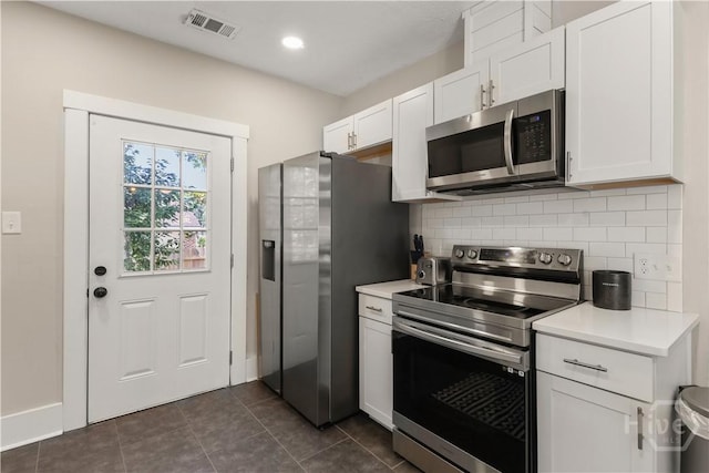 2301 Alaska St, Savannah, GA 31404 - kitchen with appliances with stainless steel finishes, backsplash, light countertops, white cabinetry, and dark tile patterned flooring