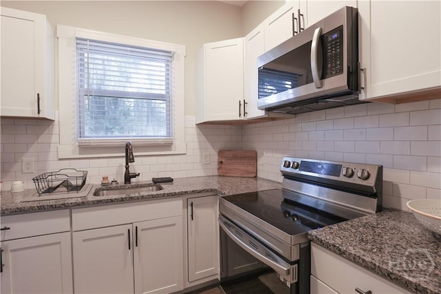 2301 Alaska St, Savannah, GA 31404 - kitchen with appliances with stainless steel finishes, white cabinetry, and decorative backsplash