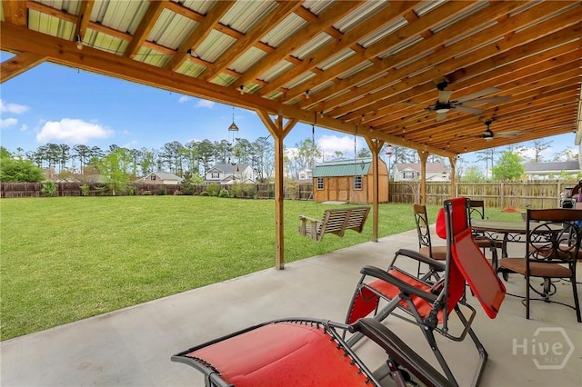 4 Broken Bit Rd, Ellabell, GA 31308 - fenced backyard with a patio, a ceiling fan, a storage unit, and outdoor dining space