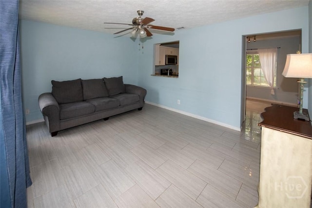 104 Ropemaker Ln, Savannah, GA 31410 - living room featuring ceiling fan, baseboards, and a textured ceiling