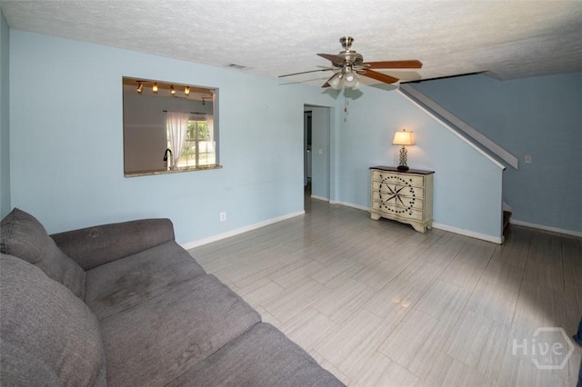 104 Ropemaker Ln, Savannah, GA 31410 - living area featuring a textured ceiling, a ceiling fan, baseboards, and stairway