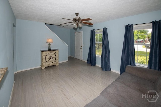 104 Ropemaker Ln, Savannah, GA 31410 - unfurnished living room with a textured ceiling, ceiling fan, and baseboards