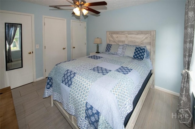 104 Ropemaker Ln, Savannah, GA 31410 - bedroom featuring two closets, wood finished floors, baseboards, and a ceiling fan