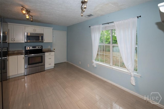 104 Ropemaker Ln, Savannah, GA 31410 - kitchen featuring stainless steel appliances, baseboards, white cabinetry, and a textured ceiling