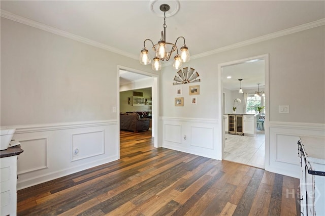 510 Braves Field Dr, Guyton, GA 31312 - unfurnished dining area featuring a chandelier, dark wood-style flooring, a wainscoted wall, beverage cooler, and crown molding