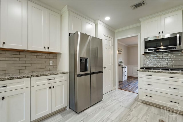 510 Braves Field Dr, Guyton, GA 31312 - kitchen with stainless steel appliances, ornamental molding, light stone counters, white cabinetry, and backsplash
