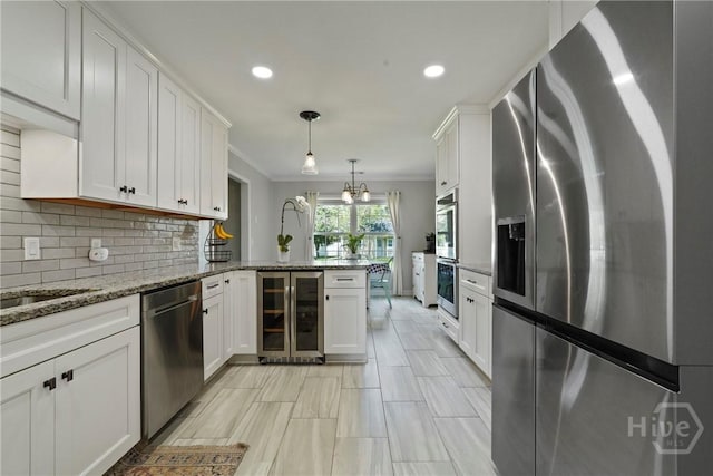 510 Braves Field Dr, Guyton, GA 31312 - kitchen with appliances with stainless steel finishes, wine cooler, a peninsula, white cabinetry, and crown molding