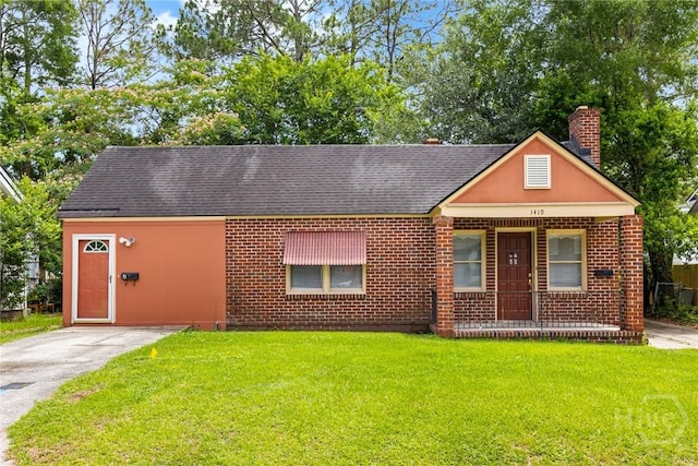 1419 E 35th St, Savannah, GA 31404 - view of front facade featuring a front yard, a chimney, roof with shingles, covered porch, and brick siding