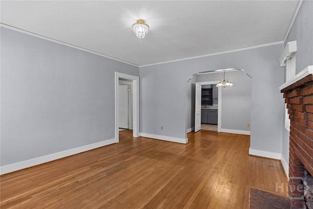 1419 E 35th St, Savannah, GA 31404 - unfurnished living room with a chandelier, wood-type flooring, arched walkways, and crown molding