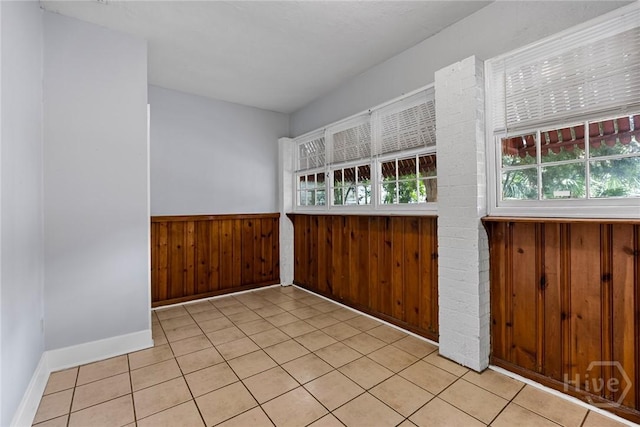 1419 E 35th St, Savannah, GA 31404 - spare room featuring a wainscoted wall, wood walls, and light tile patterned flooring