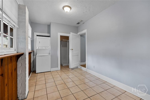 1419 E 35th St, Savannah, GA 31404 - spare room featuring estacked washer and dryer, a textured ceiling, and light tile patterned floors