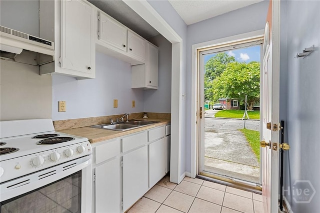 1419 E 35th St, Savannah, GA 31404 - kitchen featuring electric range, under cabinet range hood, light countertops, white cabinets, and light tile patterned floors