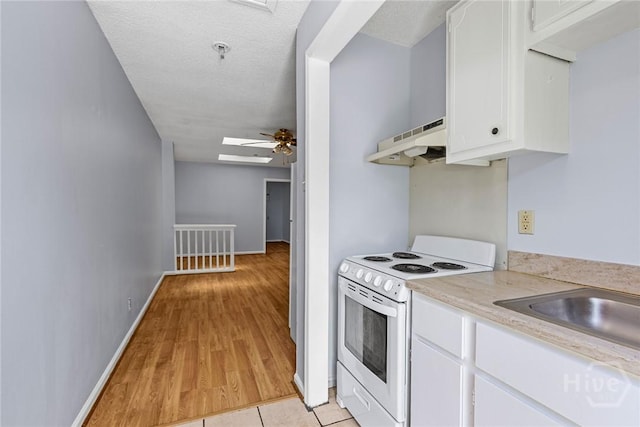 1419 E 35th St, Savannah, GA 31404 - kitchen featuring electric stove, under cabinet range hood, light countertops, white cabinetry, and ceiling fan