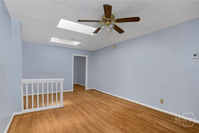 1419 E 35th St, Savannah, GA 31404 - spare room with a skylight, light wood-style floors, ceiling fan, and a textured ceiling