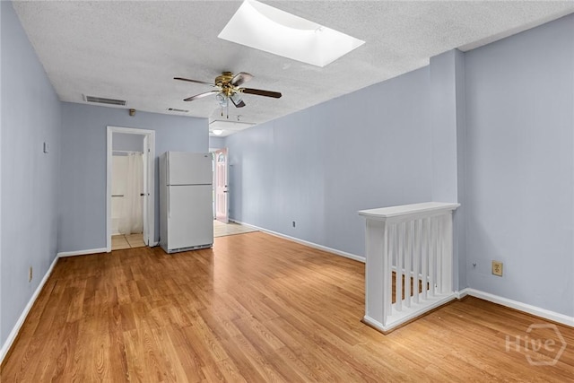 1419 E 35th St, Savannah, GA 31404 - unfurnished room featuring light wood-style flooring, a ceiling fan, a textured ceiling, and a skylight