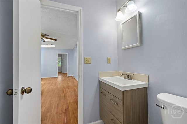 1419 E 35th St, Savannah, GA 31404 - half bath with vanity, ceiling fan, wood finished floors, and a textured ceiling