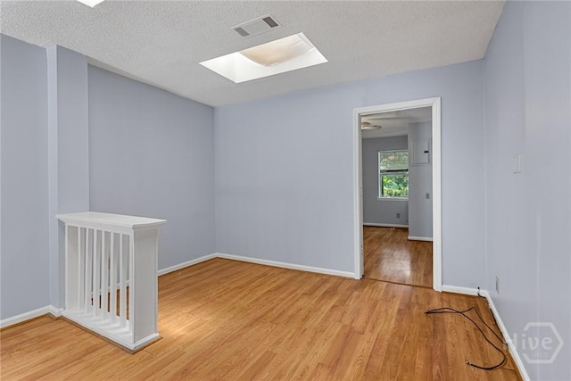 1419 E 35th St, Savannah, GA 31404 - empty room with a skylight, light wood finished floors, and a textured ceiling