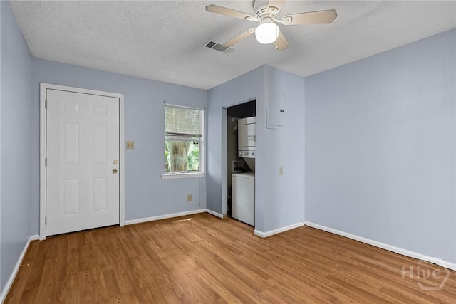 1419 E 35th St, Savannah, GA 31404 - unfurnished bedroom featuring estacked washer and dryer, light wood-type flooring, a textured ceiling, and a ceiling fan