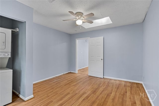 1419 E 35th St, Savannah, GA 31404 - spare room featuring stacked washer / drying machine, ceiling fan, a skylight, light wood finished floors, and a textured ceiling