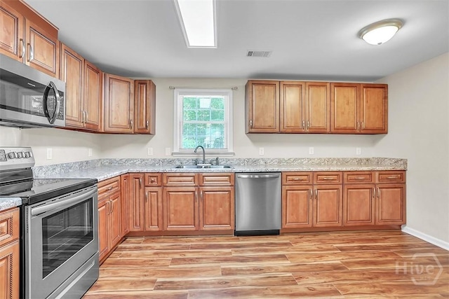 142 Bill Brown Rd, Pembroke, GA 31321 - kitchen featuring appliances with stainless steel finishes, light wood-type flooring, and brown cabinets