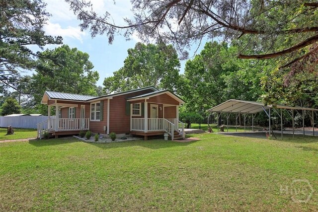 142 Bill Brown Rd, Pembroke, GA 31321 - view of property exterior featuring covered porch, a detached carport, a yard, crawl space, and a metal roof