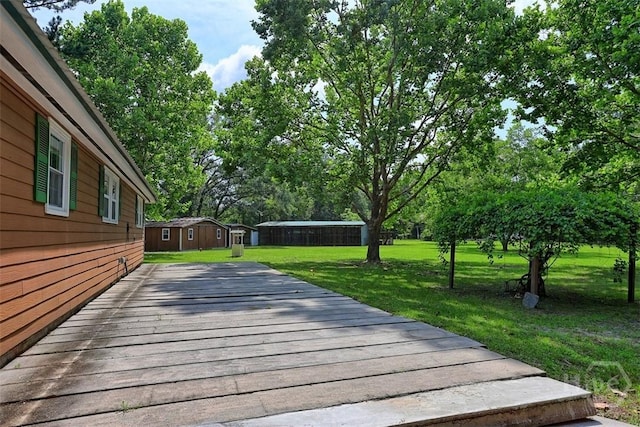 142 Bill Brown Rd, Pembroke, GA 31321 - wooden deck with a lawn and view of wooded area
