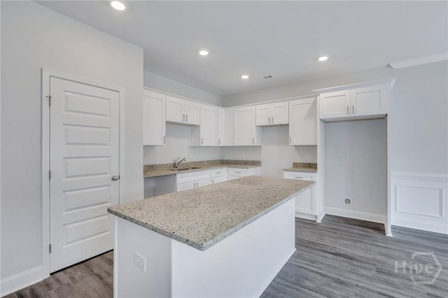 343 Governor Gwinnett Way, Pooler, GA 31322 - kitchen featuring a sink, a kitchen island, dark wood finished floors, light stone countertops, and white cabinetry