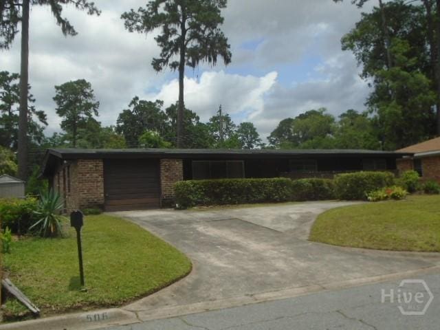 506 Mclaws St, Savannah, GA 31405 - ranch-style house featuring concrete driveway, a front yard, an attached garage, and brick siding