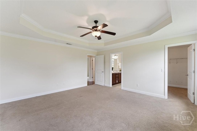 27 Drayton Ct, Midway, GA 31320 - unfurnished bedroom with a tray ceiling, ornamental molding, a spacious closet, light carpet, and baseboards