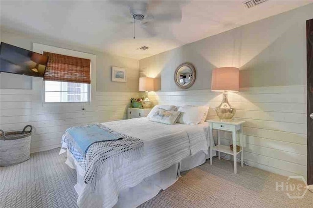 1810 Chatham Ave, Tybee Island, GA 31328 - carpeted bedroom featuring wainscoting, wood walls, and a ceiling fan
