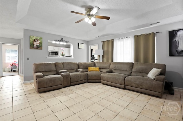1346 Ryans Way, Pooler, GA 31322 - living room featuring a tray ceiling, light tile patterned flooring, ceiling fan, baseboards, and a textured ceiling