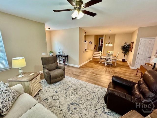 174 Regency Cir, Pooler, GA 31322 - living area with wood finished floors, baseboards, a ceiling fan, and a chandelier