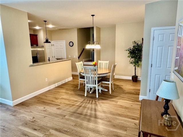 174 Regency Cir, Pooler, GA 31322 - dining area featuring a chandelier, light wood-style floors, and baseboards