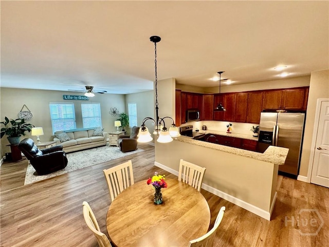 174 Regency Cir, Pooler, GA 31322 - kitchen with stainless steel appliances, a peninsula, decorative light fixtures, light wood-style floors, and ceiling fan
