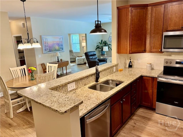 174 Regency Cir, Pooler, GA 31322 - kitchen with appliances with stainless steel finishes, light wood-style flooring, a sink, and a peninsula