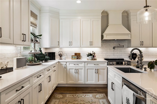 122 N St, Savannah, GA 31410 - kitchen with custom exhaust hood, stainless steel dishwasher, light countertops, hanging light fixtures, and white cabinetry