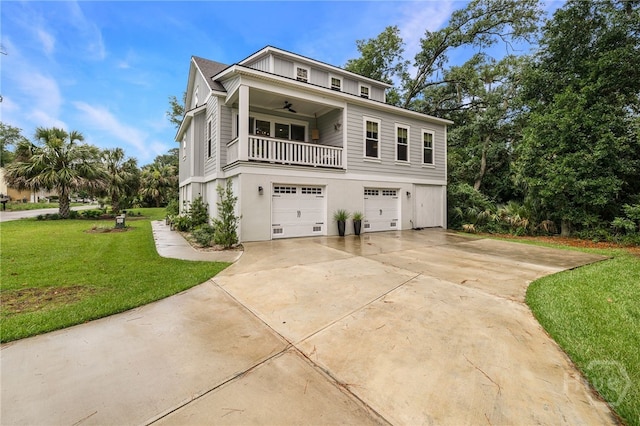 122 N St, Savannah, GA 31410 - coastal inspired home with a front lawn, an attached garage, driveway, a balcony, and ceiling fan