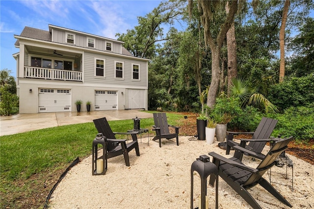 122 N St, Savannah, GA 31410 - rear view of house with a garage, a balcony, concrete driveway, board and batten siding, and a lawn