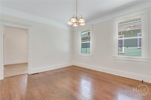 521 Seiler Ave, Savannah, GA 31401 - unfurnished room featuring baseboards, a chandelier, and hardwood / wood-style floors
