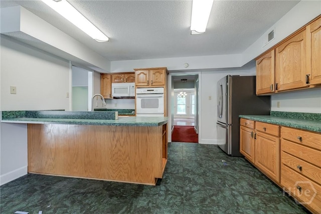 1 Shipyard Ln, Savannah, GA 31406 - kitchen featuring white appliances, dark countertops, a textured ceiling, baseboards, and a peninsula