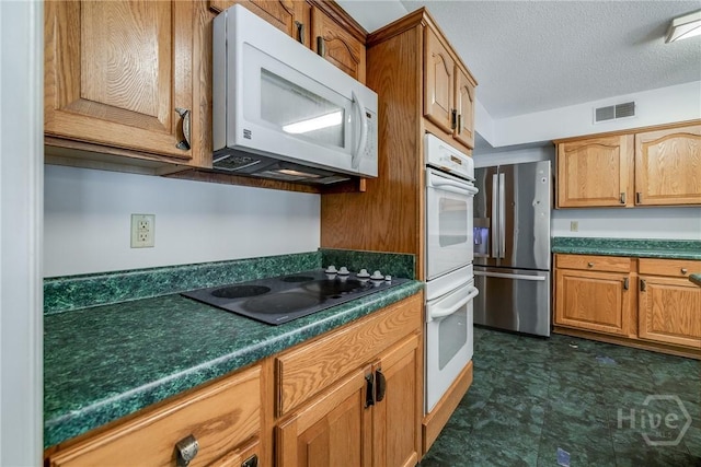 1 Shipyard Ln, Savannah, GA 31406 - kitchen with white appliances, dark countertops, a textured ceiling, and brown cabinets